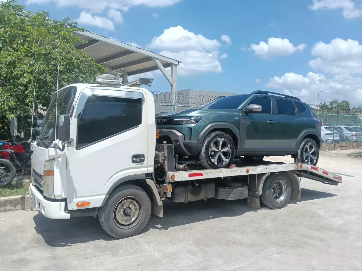 Grúa de plataforma transportando una camioneta
